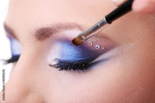 Quadro em tela Beautiful female eyes with bright blue make-up and brush