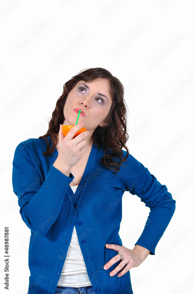 Girl drinking orange juice on a white background Girl drinking orange juice on a white background