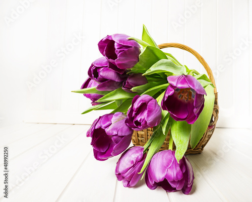 Fototapeta Naklejka Na Ścianę i Meble -  purple tulips in a basket on white wooden table