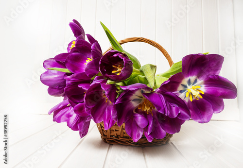 Fototapeta Naklejka Na Ścianę i Meble -  purple tulips in a basket on a white wooden table
