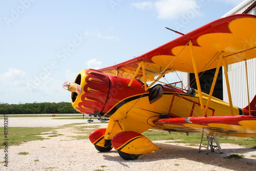 Colorful vintage airplane by a hanger