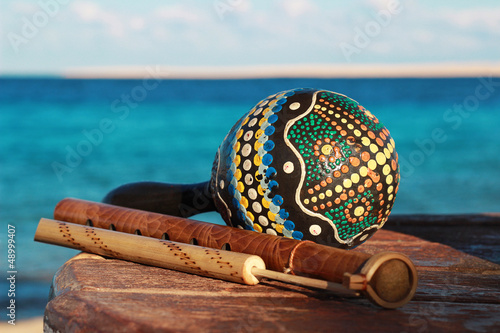Музыкальные инструменты маракас, дудка и флейта на фон моря