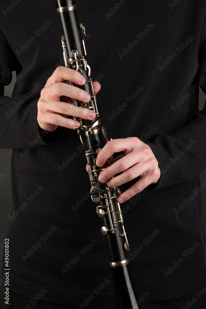 Fototapeta premium Musician playing on clarinet on black background