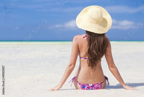back view of beautiful young woman at beach enjoying the sun © el.rudakova