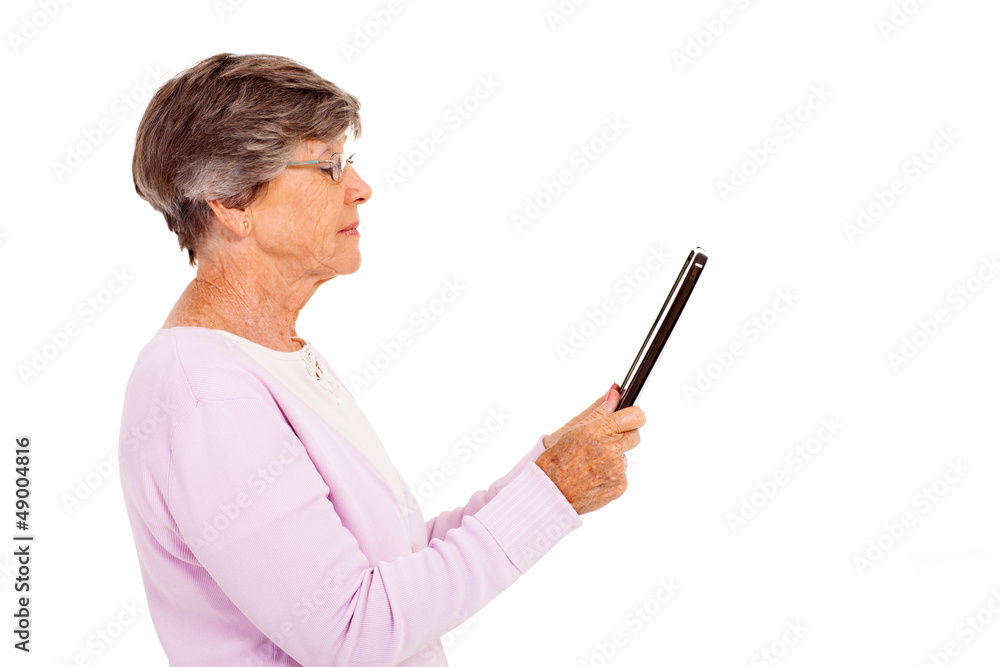 elderly woman reading book on tablet computer isolated on white elderly woman reading book on tablet computer isolated on white