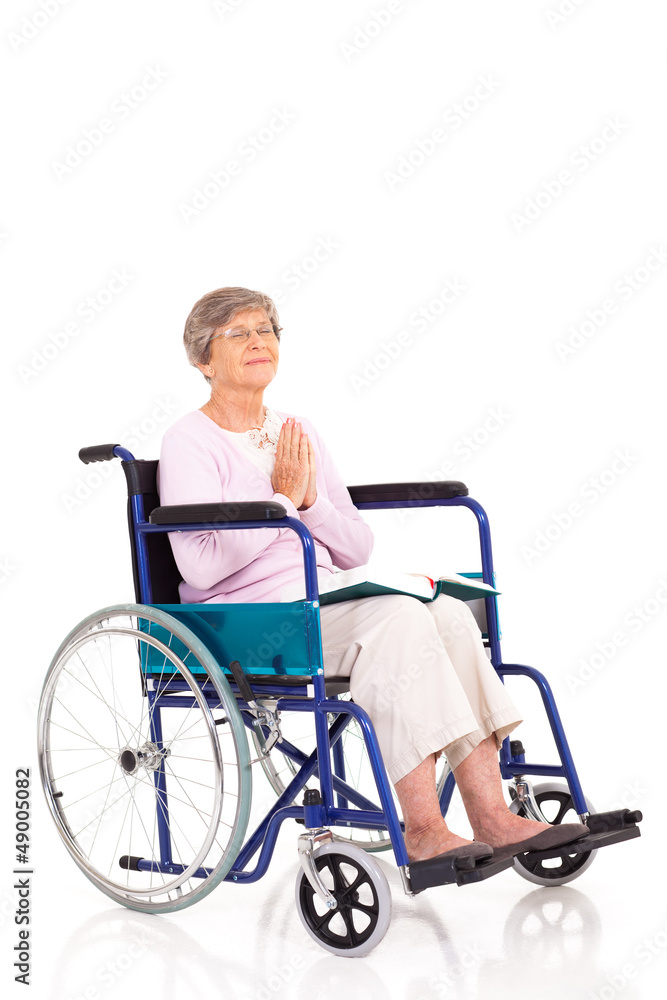 elderly woman sitting on wheelchair and praying elderly woman sitting on wheelchair and praying