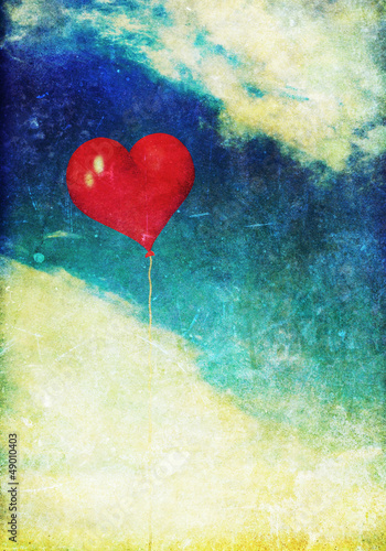 Vintage photo of red heart balloon in the sky
