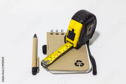 black tape measure accessories, notebook, pen on background whit