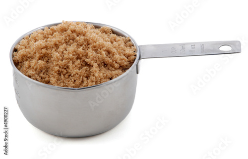 Light brown soft / muscovado sugar presented in a cup measure