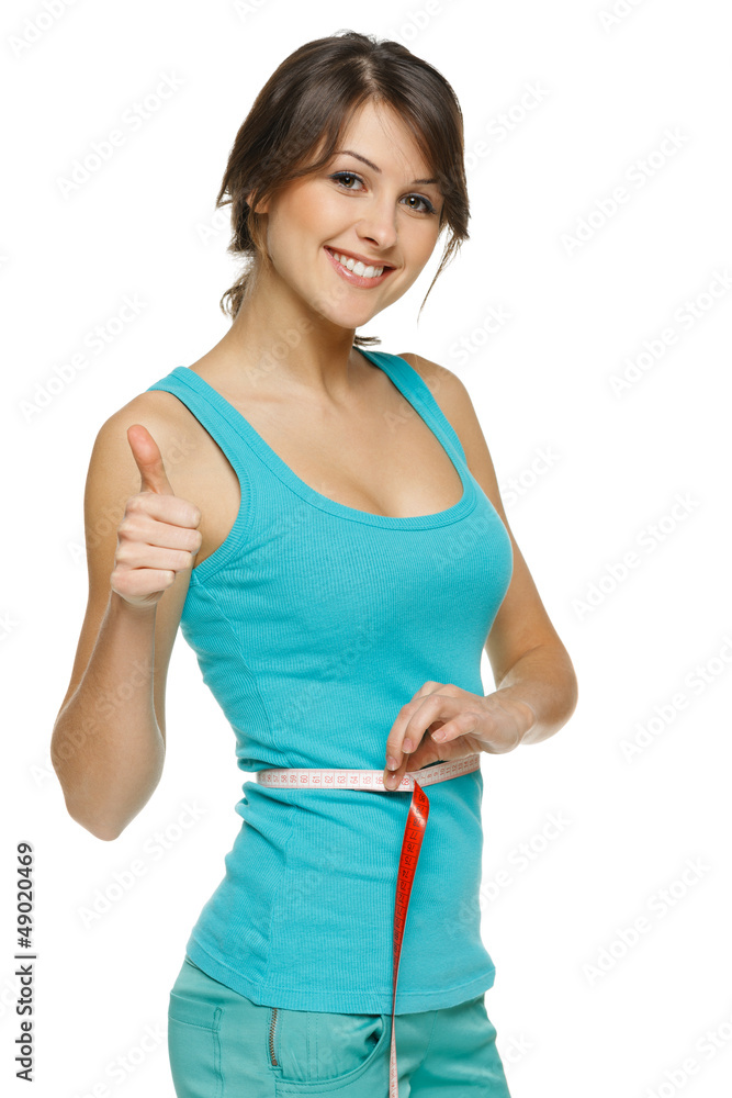 Woman measuring her waist with tape and showing thumb up Woman measuring her waist with tape and showing thumb up