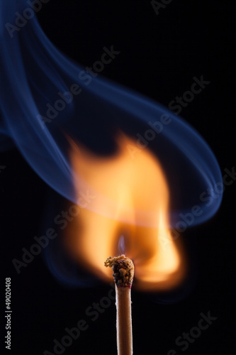 Ignition of a match, with smoke on dark background