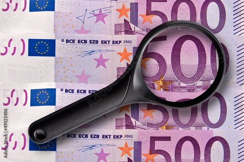 Loupse posée sur plusieurs billets de banque de 500 euros, concept d'enquête et analyse sur les finances, l'impôt, l'argent en Europe photo