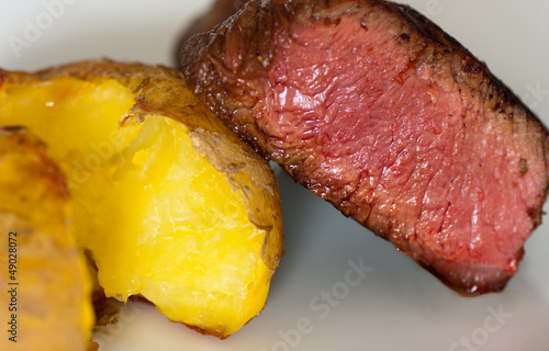 closeup of a beef steak with baked potato