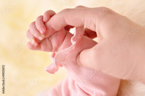 Child's hand holding mother finger