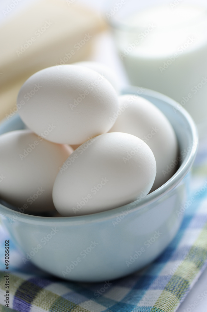 Bowl of eggs with milk and cheese in background. Bowl of eggs with milk and cheese in background.