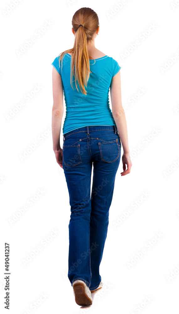 back view of walking woman in jeans and shirt. back view of walking woman in jeans and shirt.