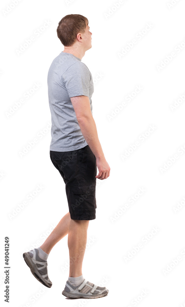 Back view of walking handsome man in shorts and sneakers. Back view of walking handsome man in shorts and sneakers.