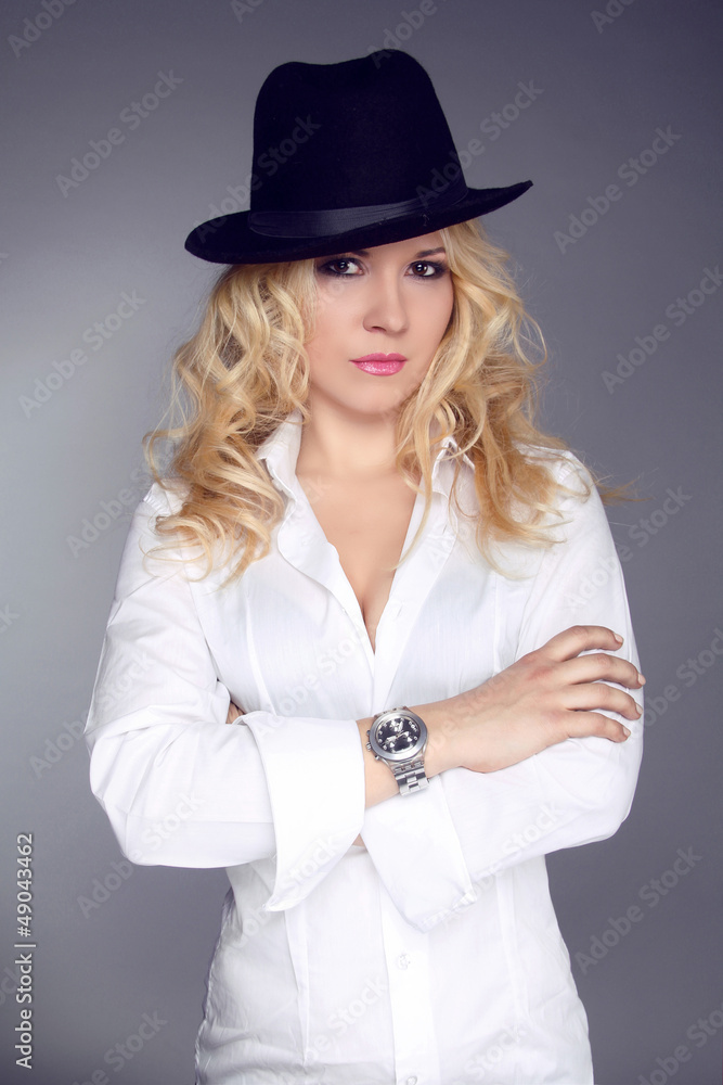 Woman wearing in white shirt and black hat isolated on grey back Woman wearing in white shirt and black hat isolated on grey back