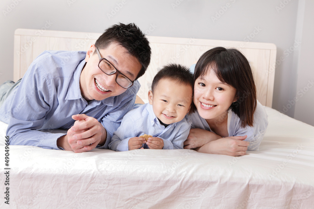 happy family lying on bed