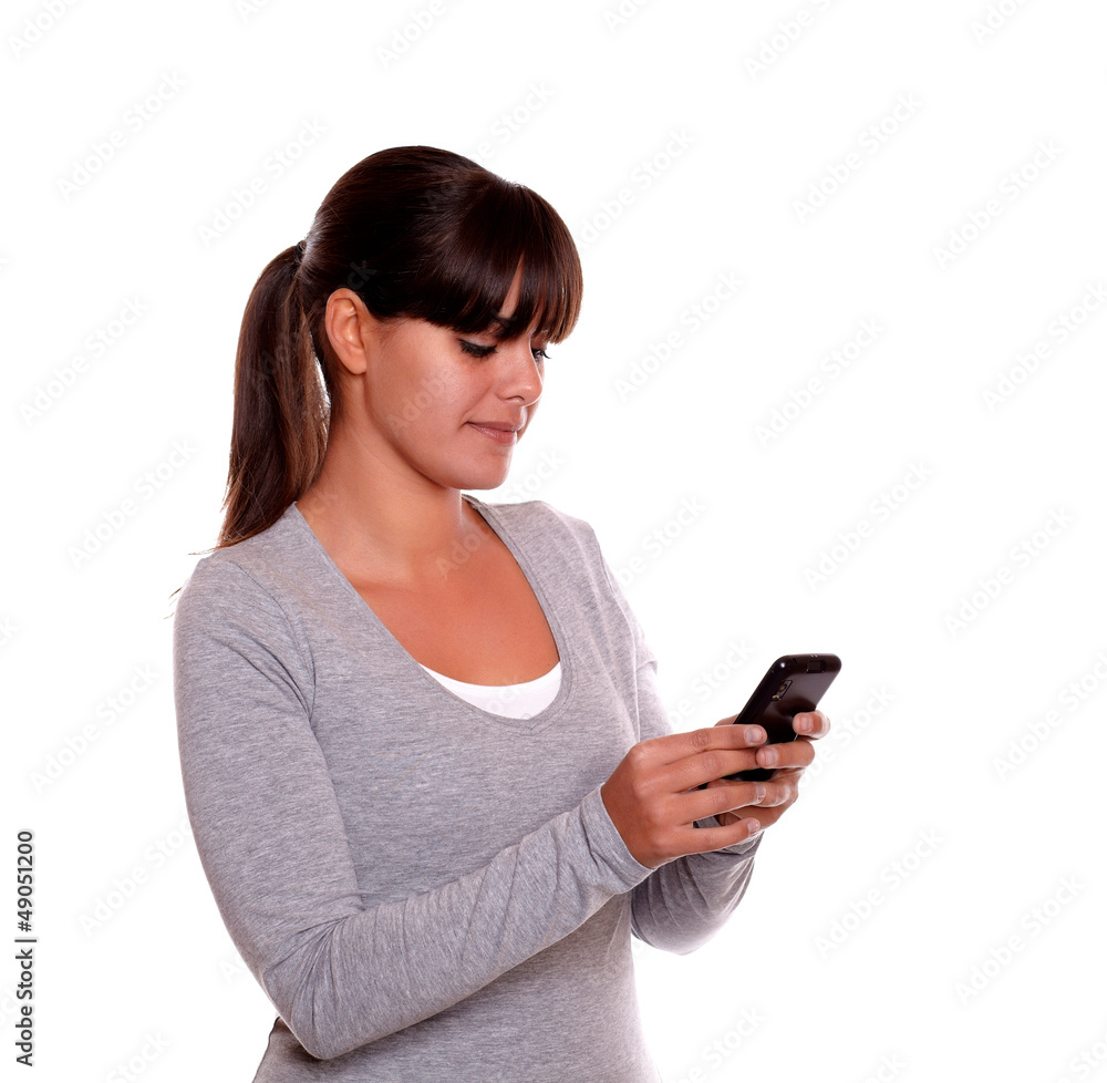Young woman sending a message with her cellphone Young woman sending a message with her cellphone