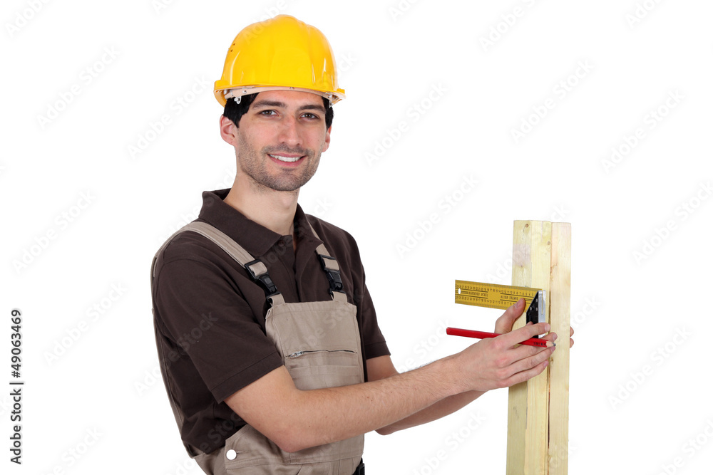 portrait of young carpenter taking measurements portrait of young carpenter taking measurements