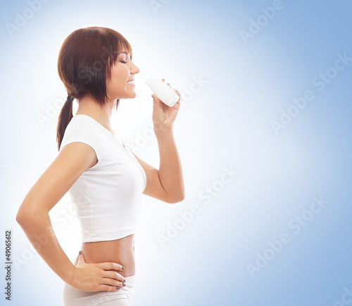 Young sporty woman drinking from the bottle