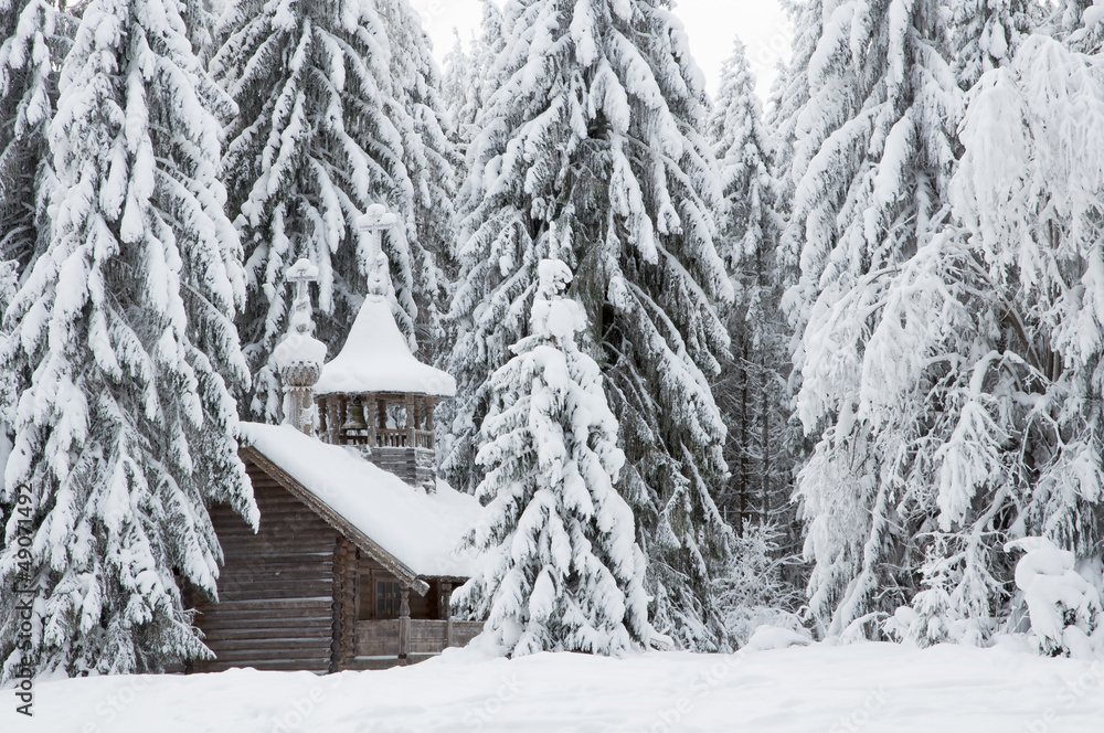 Деревянная часовня в снежном лесу. Зима, север
