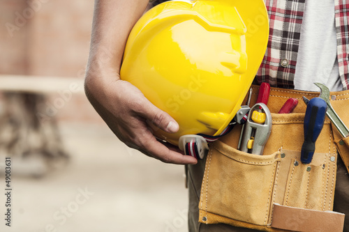 Close-up of hard hat holding by construction worker photo