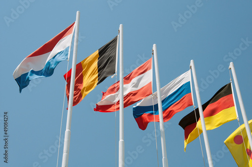 Flags of different countries on a background of blue sky