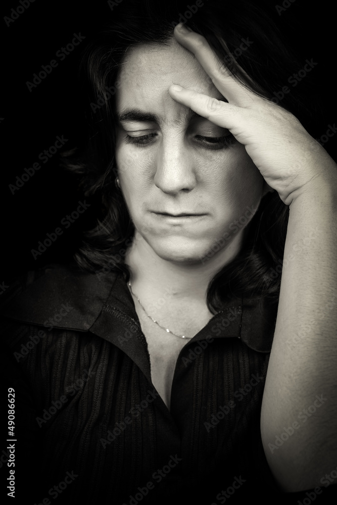Fototapeta premium Black and white portrait of a sad hispanic woman with a headache