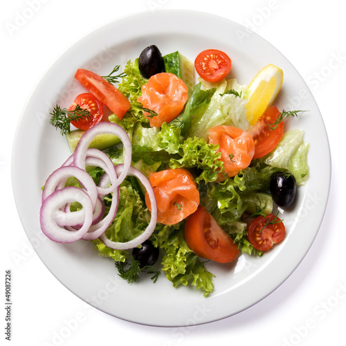 Salad with salmon served on white plate