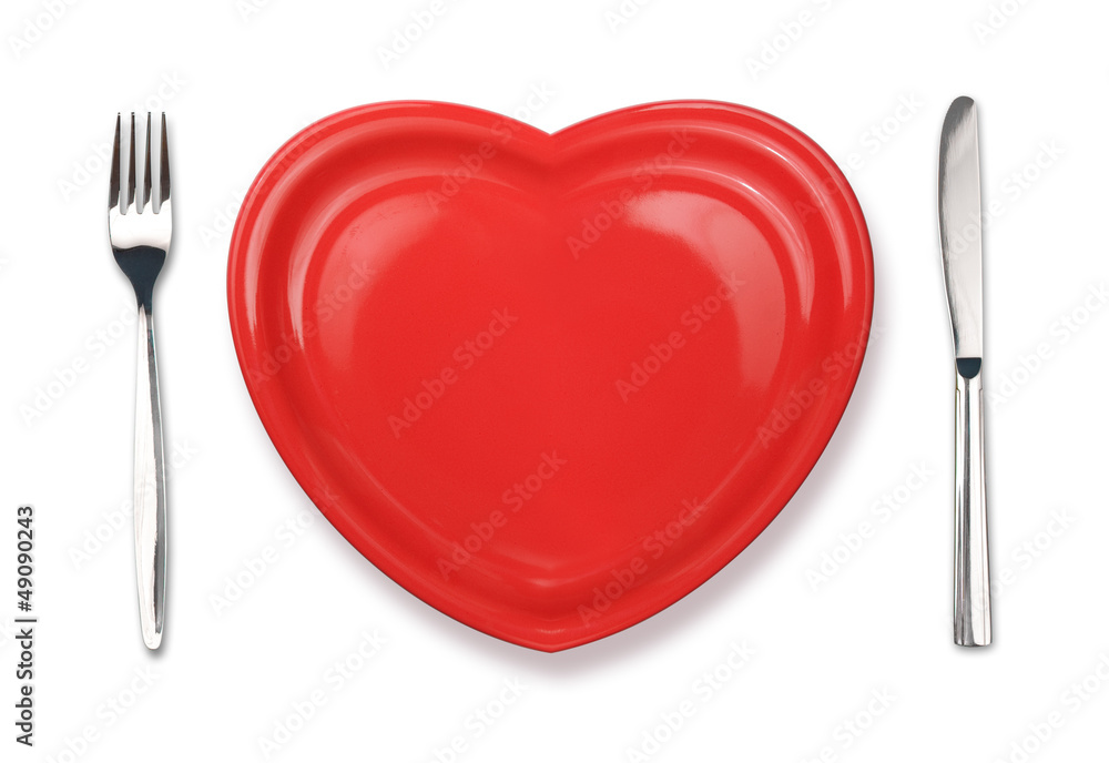 Knife, red plate in heart shape and fork isolated on white Knife, red plate in heart shape and fork isolated on white