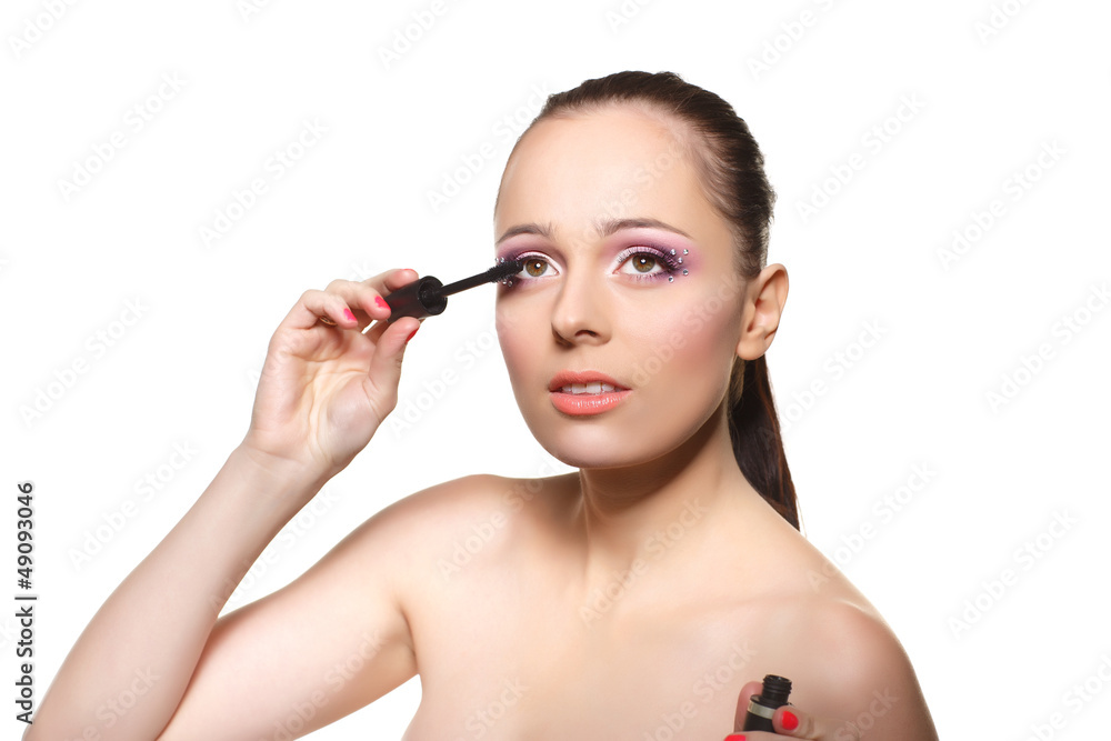 Woman applying mascara for eyelashes.