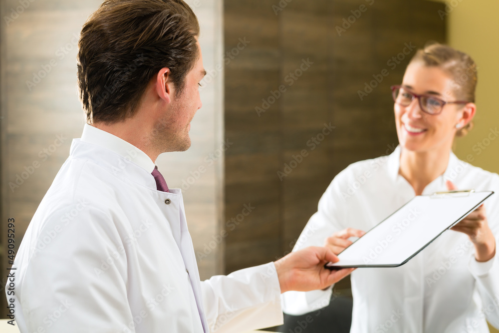 Dentist and nurse with clipboard in clinic Dentist and nurse with clipboard in clinic