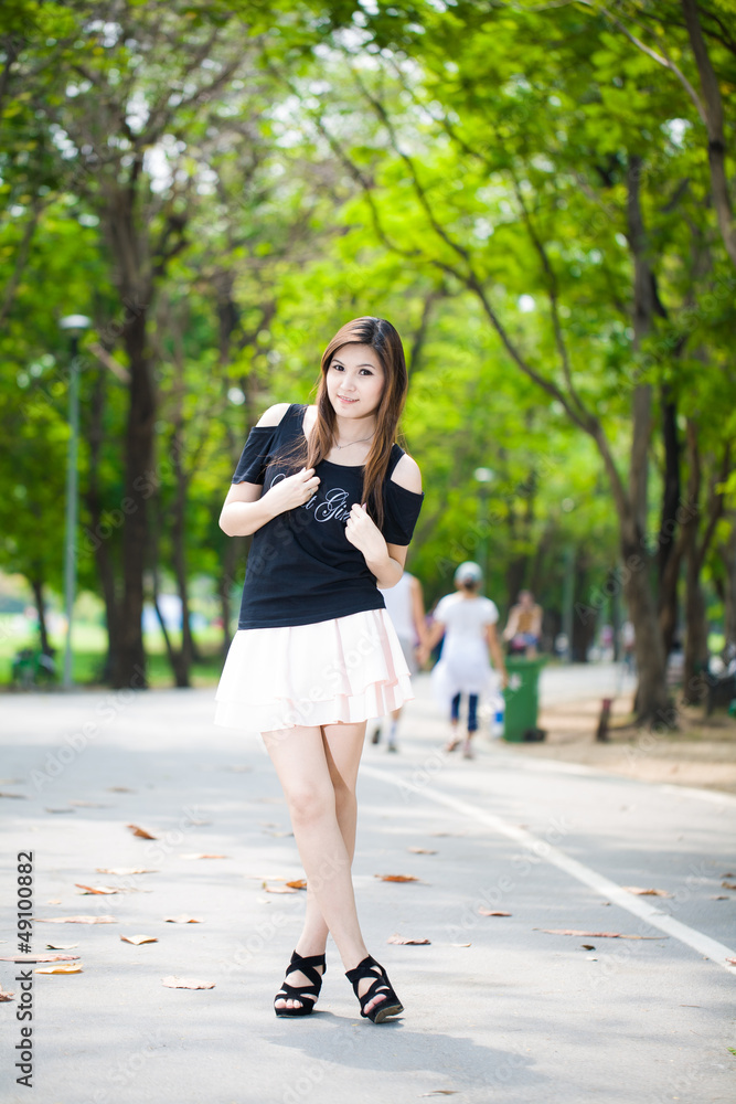 Young woman walking on path in city park