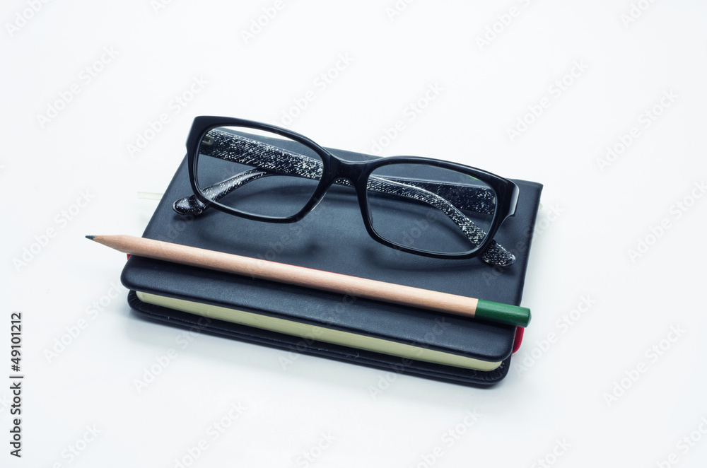 Pencil and black frame glasses on the notebook Pencil and black frame glasses on the notebook