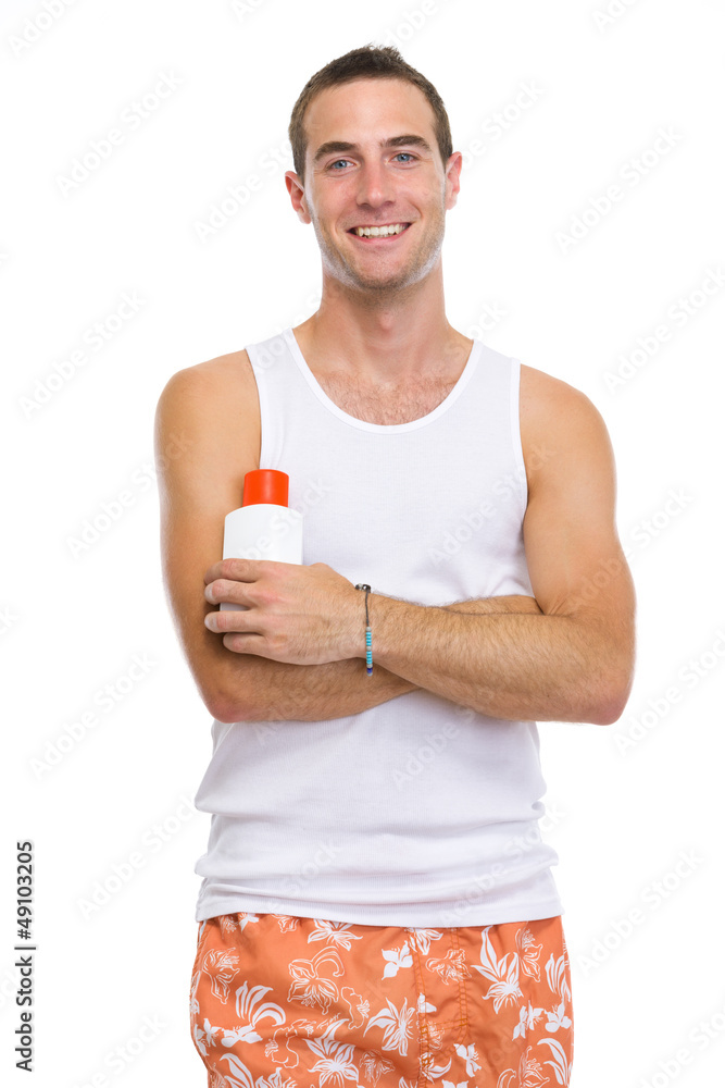 Portrait of smiling young man showing sun screen creme