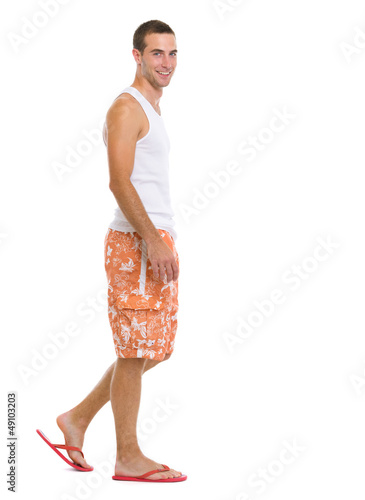 Full length portrait of happy young man going sideways photo