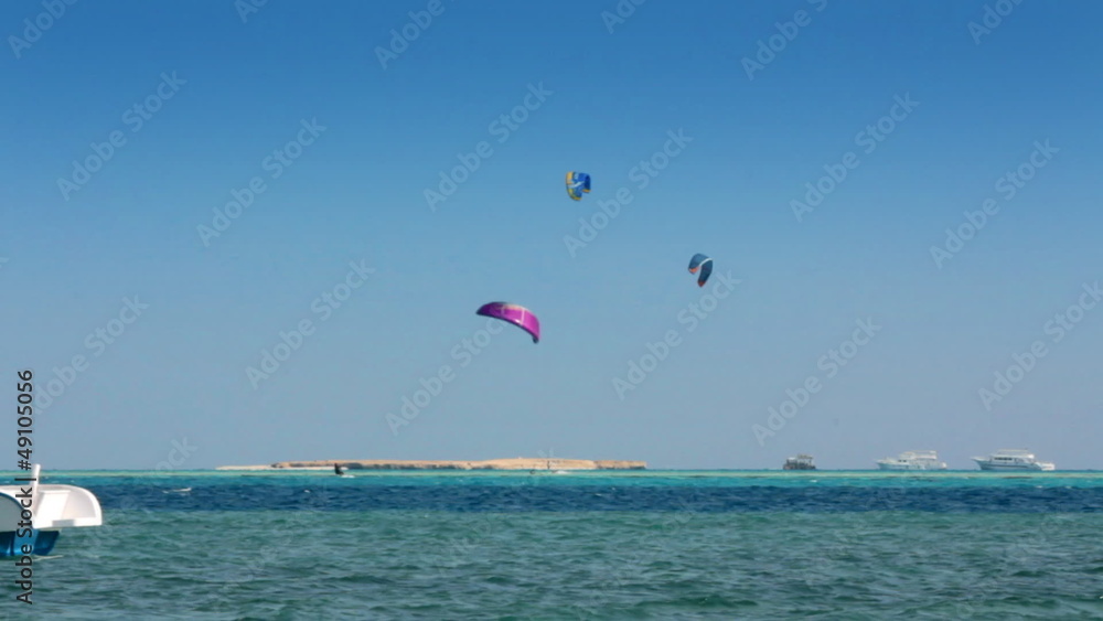 kite surfing - surfers on blue sea surface kite surfing - surfers on blue sea surface