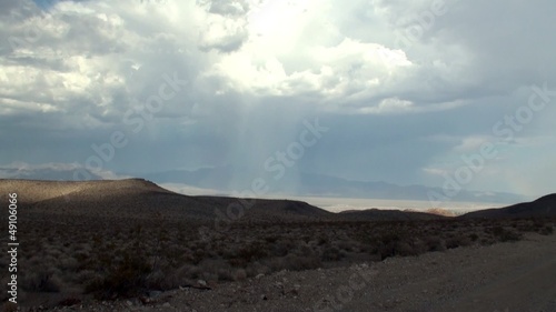 Pillar of rain, cumulonimbus cloud & sun gleams at the valley. photo