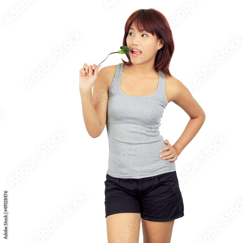 Isolated young asian woman with a picec of brocolli