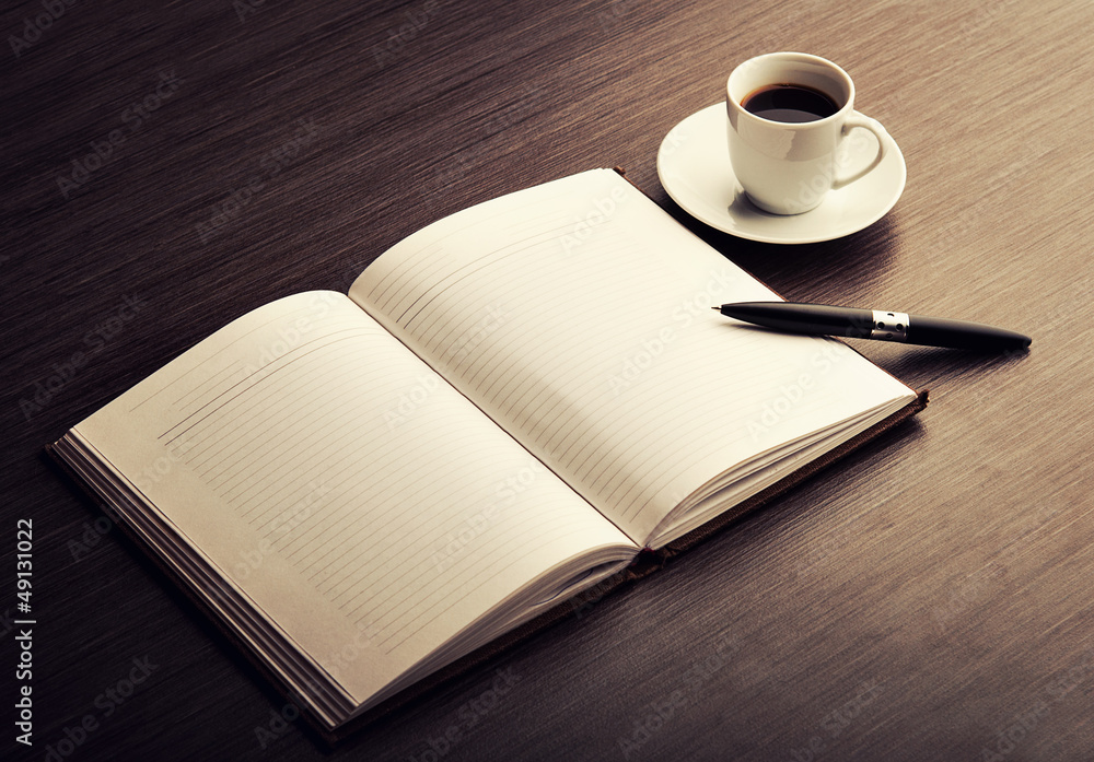 Open a blank white notebook, pen and coffee on the desk Open a blank white notebook, pen and coffee on the desk