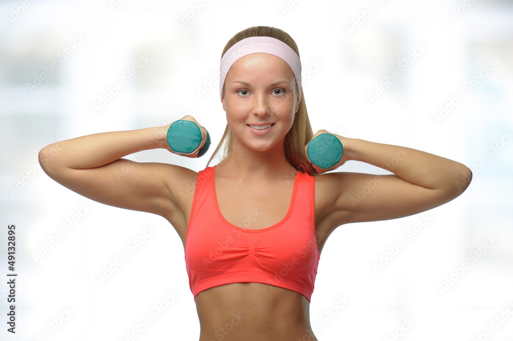 Image of blonde smiling woman with barbell in hand Image of blonde smiling woman with barbell in hand