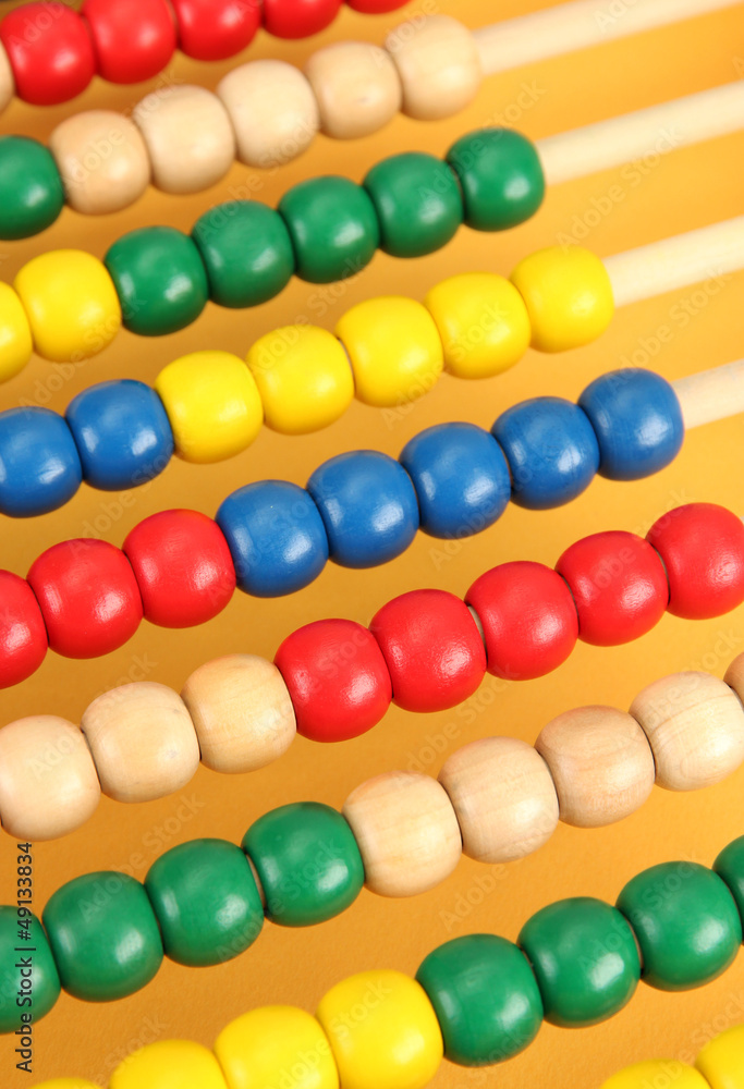 Bright wooden toy abacus, on yellow background Bright wooden toy abacus, on yellow background