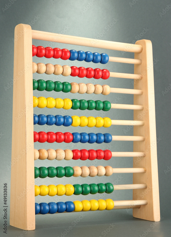 Bright wooden toy abacus, on grey background Bright wooden toy abacus, on grey background