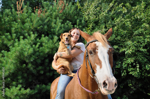 Young adult woman with her horse and dog