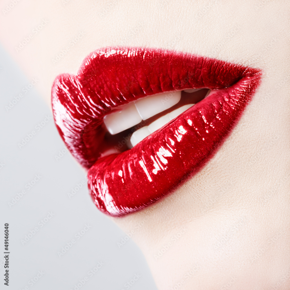Naklejka premium Piękna kobieta z czerwonymi błyszczącymi ustami z bliska