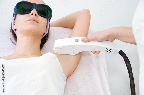 Young woman receiving epilation laser treatment photo