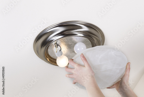 Fotografie Preparing to Replace Light Bulb