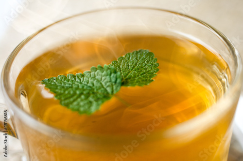 hot brewed tea with mint leaf in a transparent cup